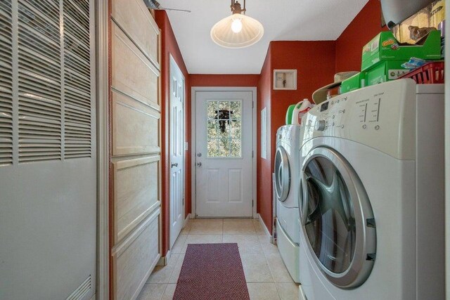 laundry area with light tile patterned floors, a heating unit, baseboards, washing machine and dryer, and laundry area