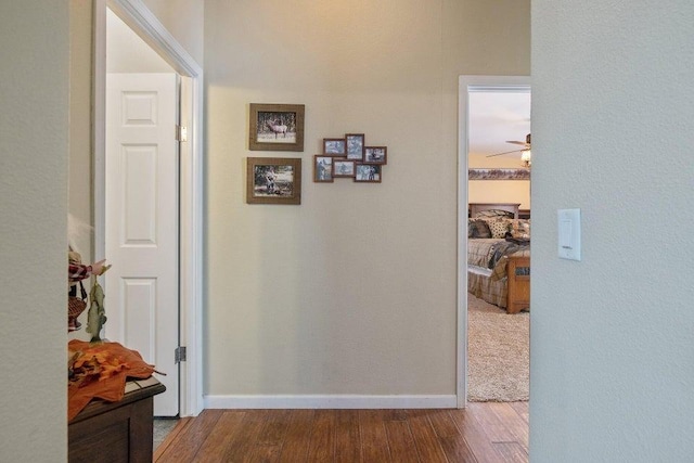 hall featuring baseboards and wood finished floors