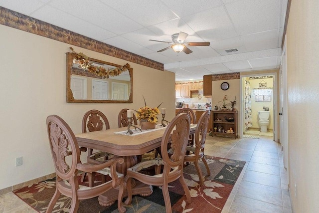 dining room with visible vents, ceiling fan, light tile patterned floors, and a paneled ceiling