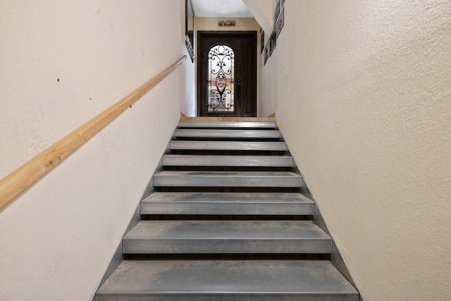 staircase with a textured wall