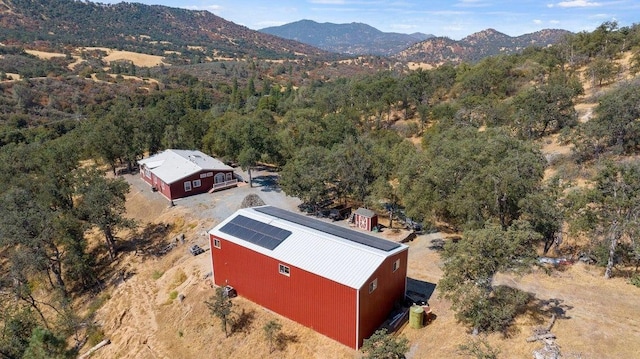 drone / aerial view featuring a wooded view and a mountain view