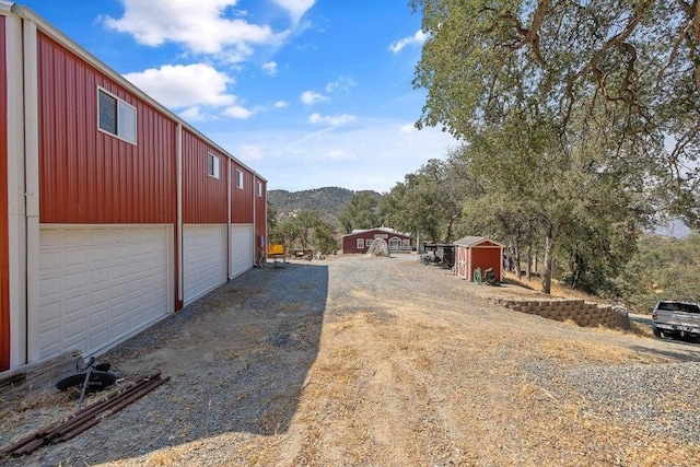 view of yard with driveway, an outbuilding, and a garage