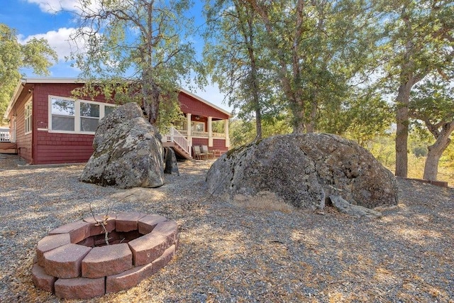 view of yard featuring stairs and an outdoor fire pit