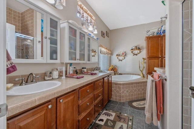 full bathroom featuring a stall shower, tile patterned floors, a bath, and a sink