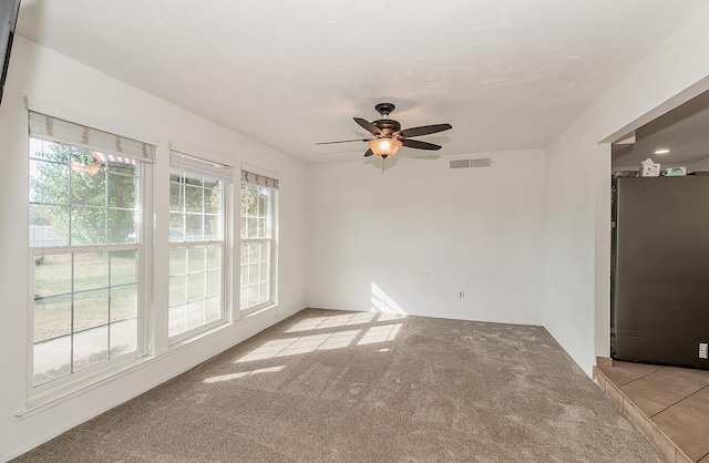 spare room featuring ceiling fan and light carpet