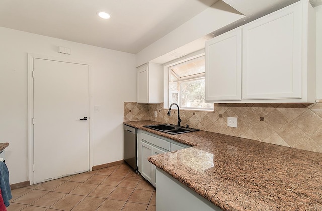 kitchen with dishwasher, decorative backsplash, white cabinets, light tile patterned flooring, and sink