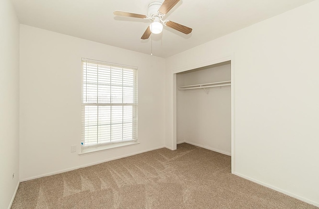 unfurnished bedroom featuring ceiling fan, a closet, and light carpet