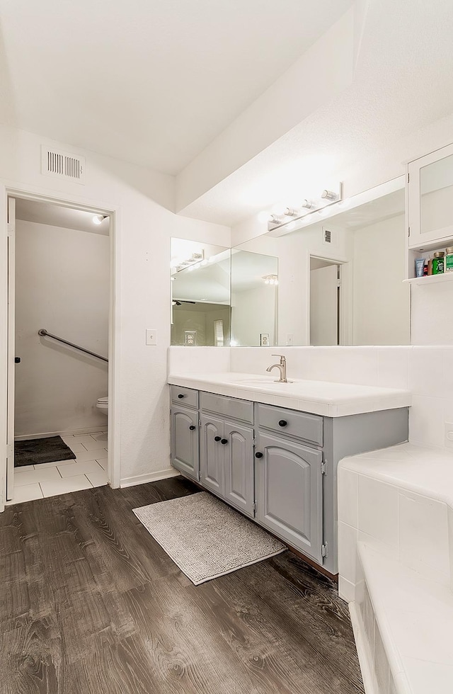 bathroom featuring toilet, wood-type flooring, and vanity