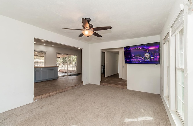 unfurnished living room featuring carpet flooring and ceiling fan