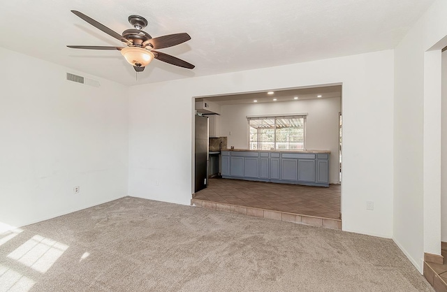 unfurnished living room with ceiling fan and light carpet