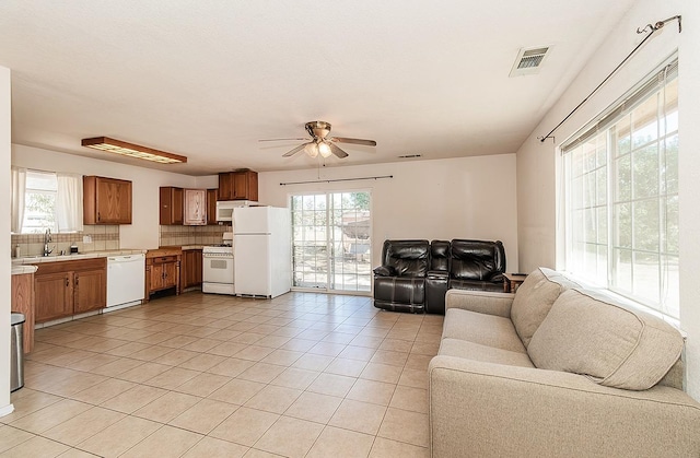 living room featuring sink, light tile patterned flooring, ceiling fan, and a wealth of natural light