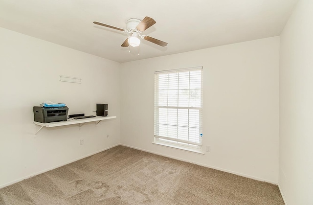 carpeted spare room featuring ceiling fan