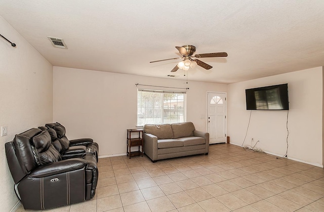 tiled living room featuring a textured ceiling and ceiling fan