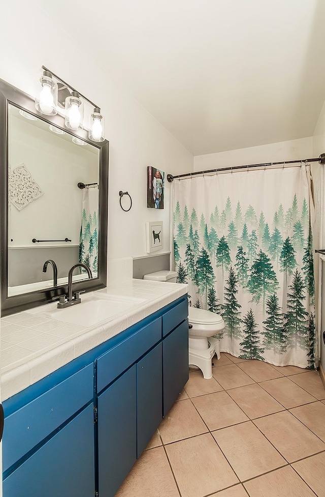 bathroom featuring vanity, tile patterned floors, and toilet