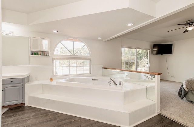 bathroom featuring hardwood / wood-style floors, vanity, ceiling fan, and a bathtub