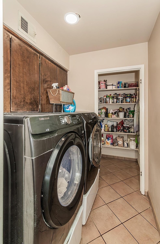 washroom with washing machine and dryer and light tile patterned flooring