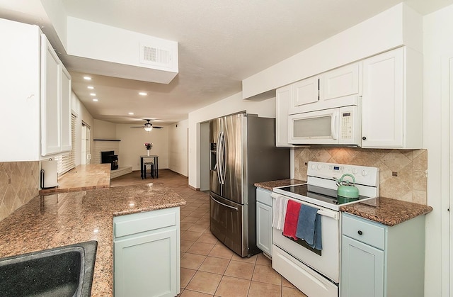 kitchen featuring white appliances, tasteful backsplash, ceiling fan, white cabinets, and light tile patterned flooring