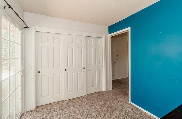 unfurnished bedroom with a closet and carpet