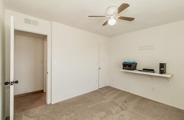 carpeted empty room featuring ceiling fan