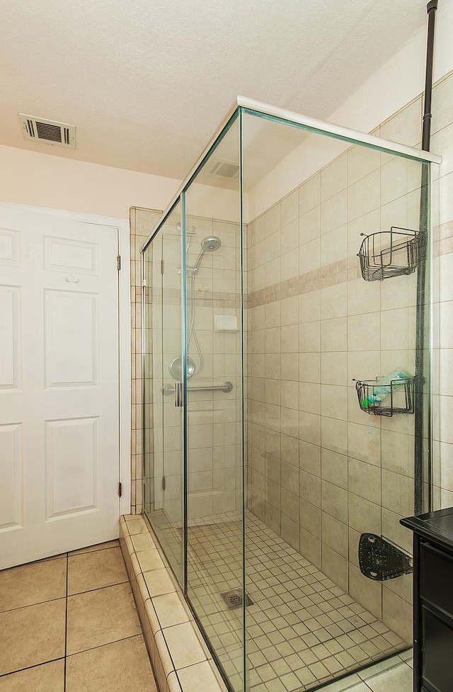 bathroom with walk in shower and tile patterned flooring