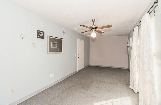 spare room with ceiling fan, a textured ceiling, and carpet flooring