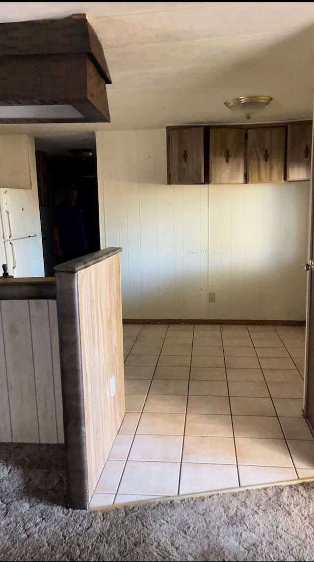 interior space featuring tile patterned floors and wooden walls