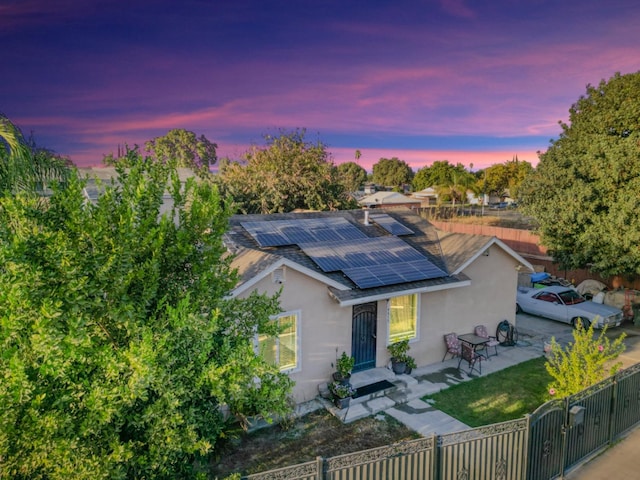 view of front of property with solar panels and a patio area