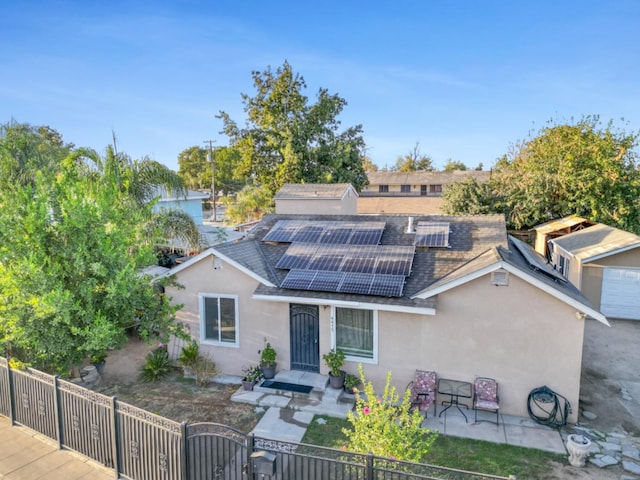 view of front of house featuring solar panels and a patio area