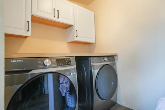 clothes washing area featuring cabinets and independent washer and dryer