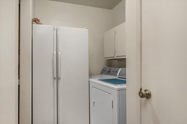 clothes washing area featuring cabinets and washing machine and dryer