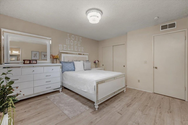 unfurnished bedroom with a closet, light hardwood / wood-style floors, and a textured ceiling