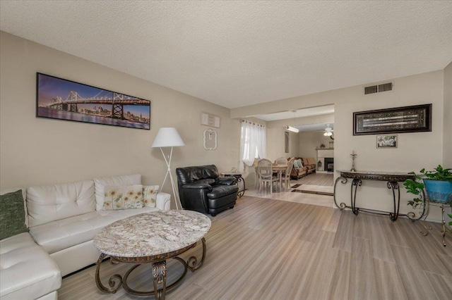 living room featuring light hardwood / wood-style floors and a textured ceiling