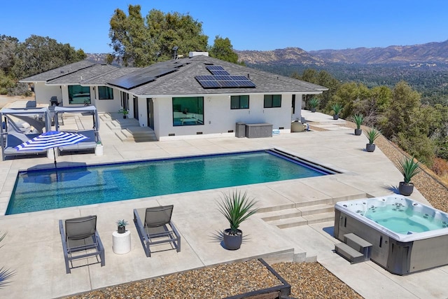 view of swimming pool with a mountain view, a hot tub, and a patio area