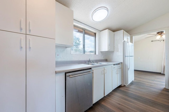 kitchen featuring light countertops, stainless steel dishwasher, freestanding refrigerator, white cabinets, and a sink