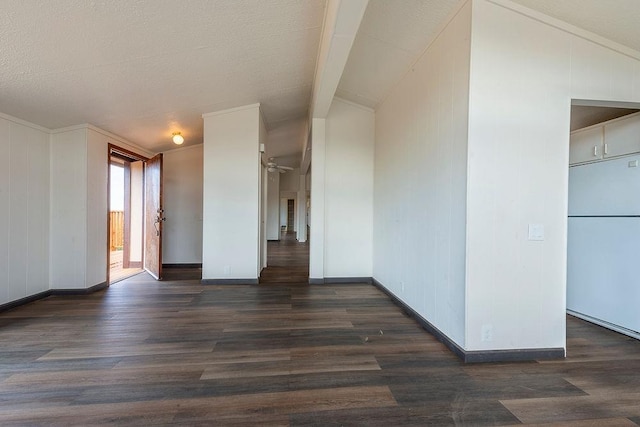 unfurnished room with baseboards, vaulted ceiling, and dark wood finished floors