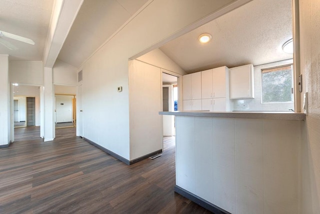 kitchen featuring vaulted ceiling with beams, light countertops, dark wood-type flooring, and white cabinets