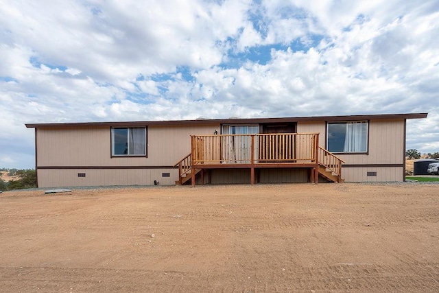 view of front of property with crawl space, a wooden deck, and stairs