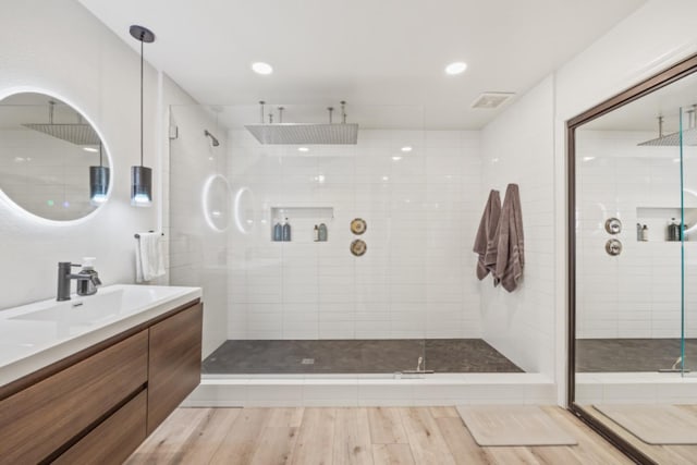 bathroom with vanity, hardwood / wood-style flooring, and a shower with shower door