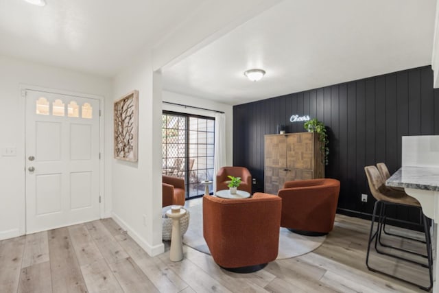 foyer featuring light hardwood / wood-style floors and wooden walls