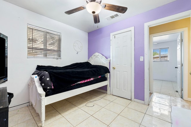 tiled bedroom featuring ceiling fan