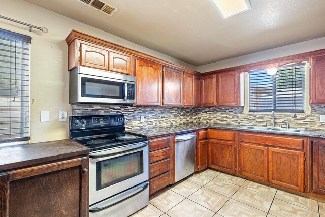 kitchen featuring decorative backsplash, appliances with stainless steel finishes, and sink