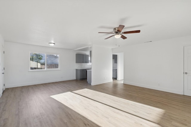 unfurnished living room with ceiling fan and hardwood / wood-style flooring