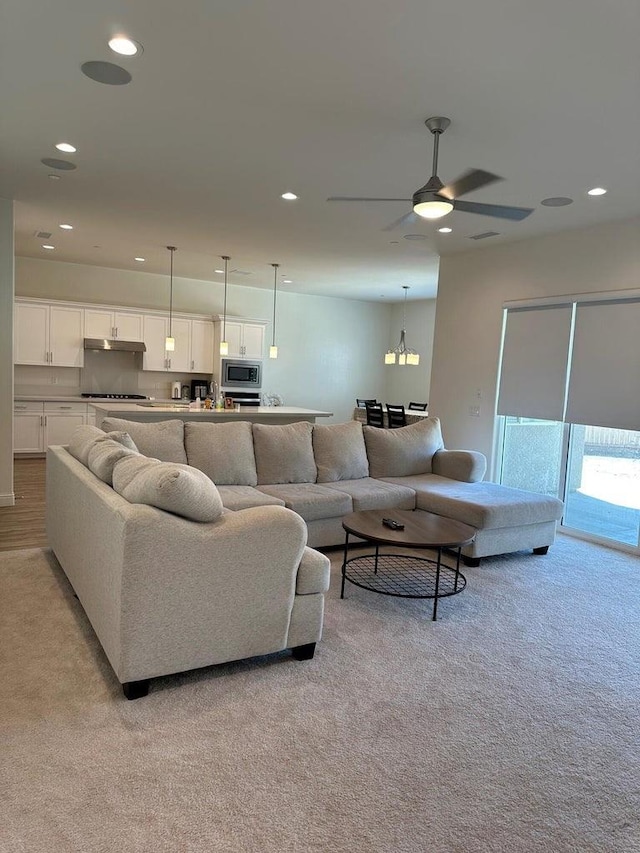 living room featuring light colored carpet and ceiling fan