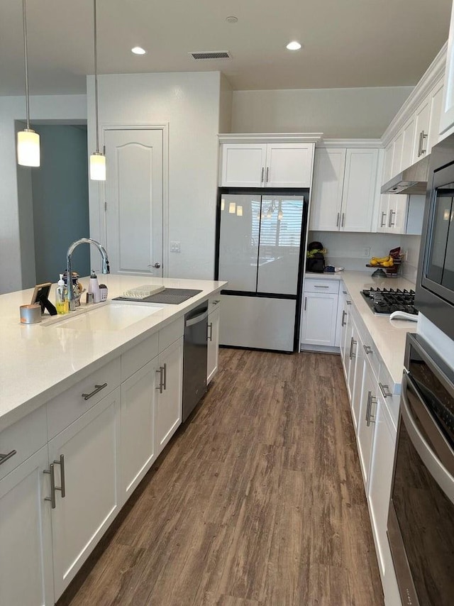 kitchen with pendant lighting, white cabinetry, dark hardwood / wood-style flooring, and stainless steel appliances