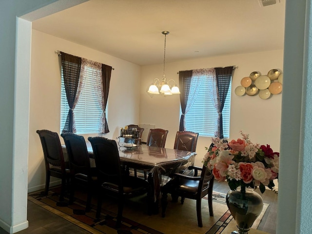 dining room with wood-type flooring and a chandelier