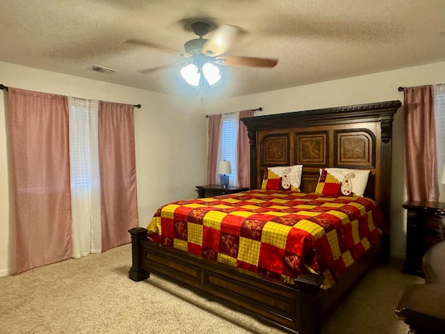 carpeted bedroom with ceiling fan and a textured ceiling