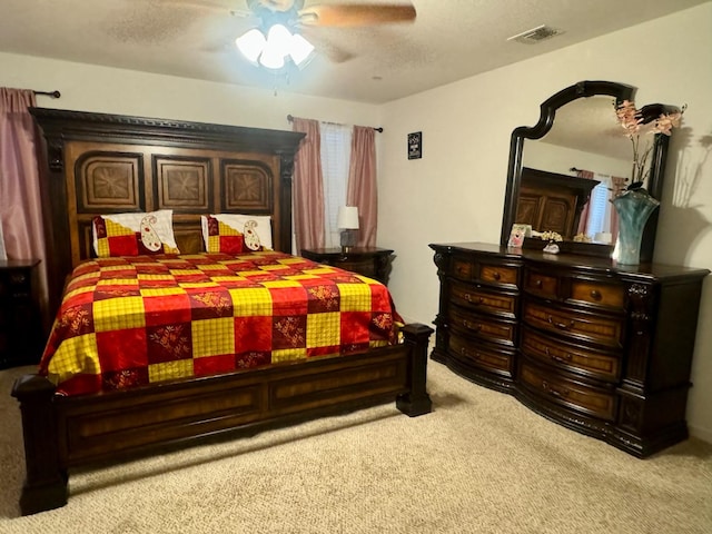 carpeted bedroom with ceiling fan and a textured ceiling