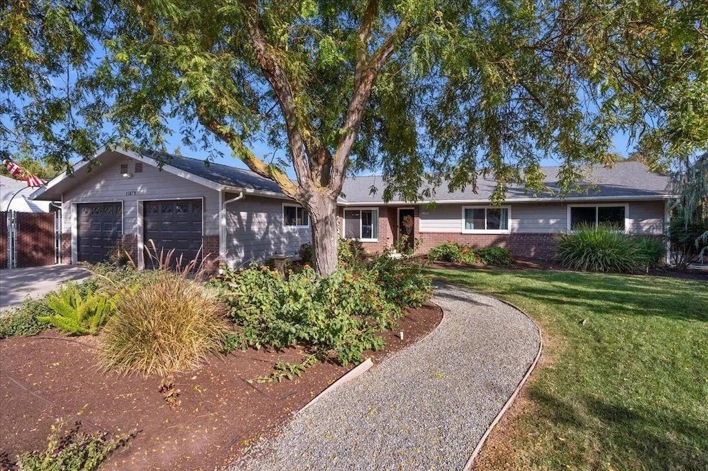 single story home with a garage and a front lawn