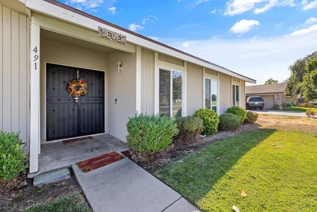 doorway to property featuring a garage and a yard