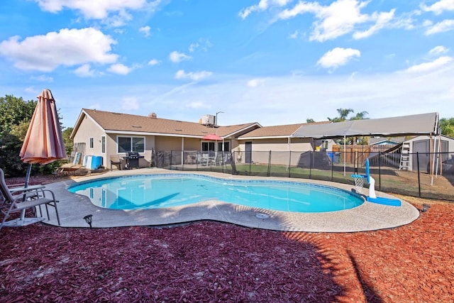 view of pool with a patio and a shed